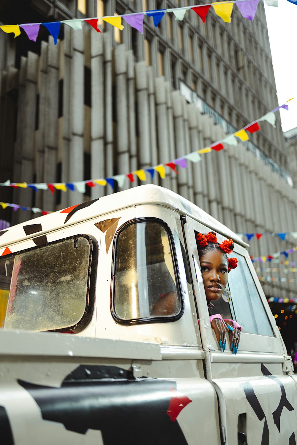 a woman in a white jeep driving down a street