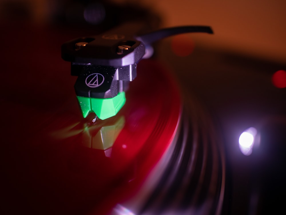 a close up of a turntable with a green light