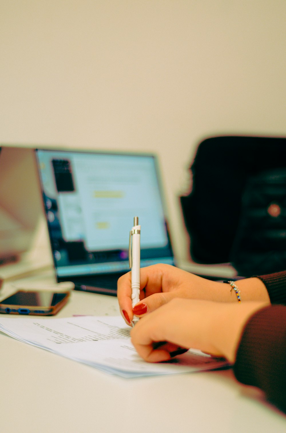 a woman sitting at a desk writing on a piece of paper