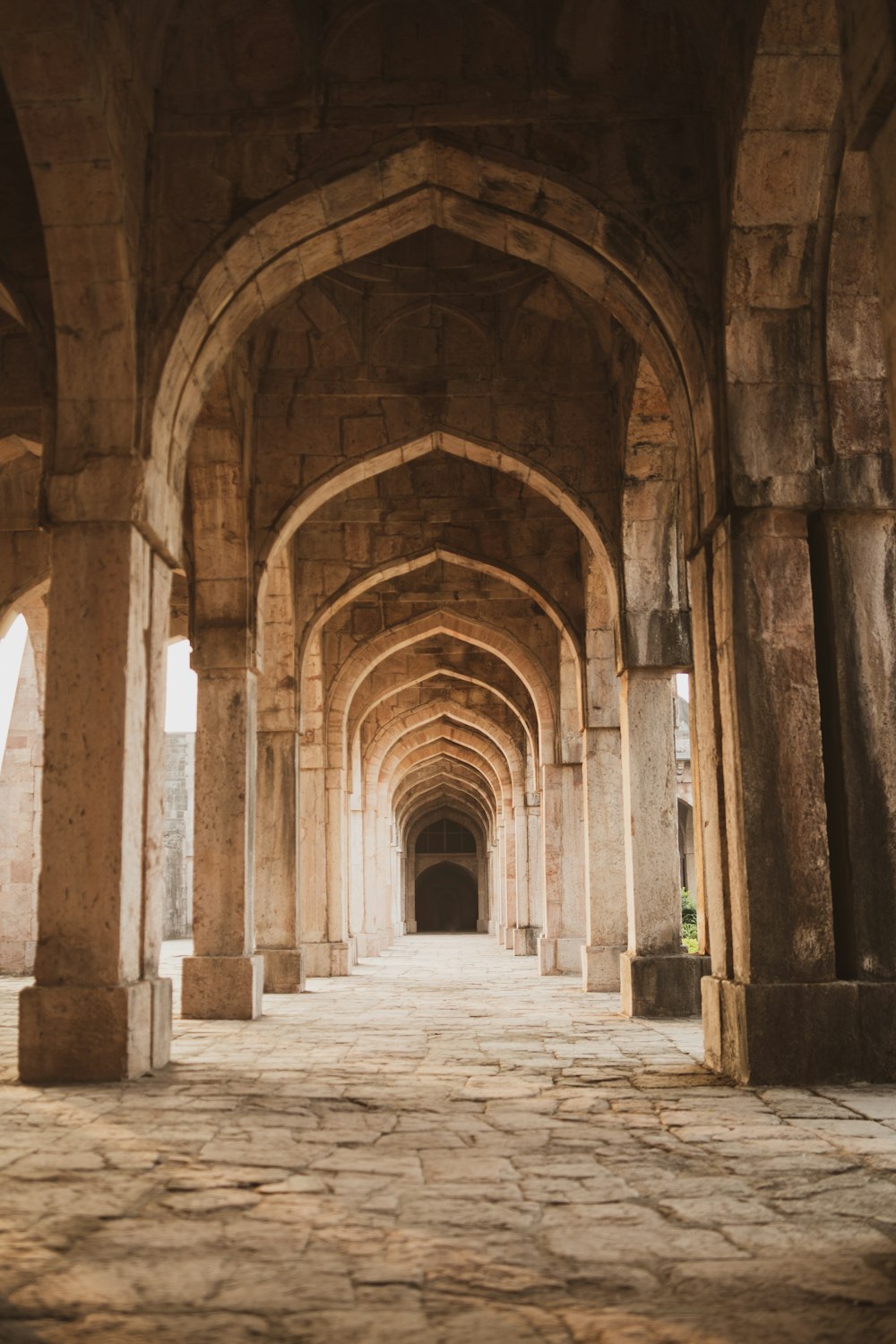 a long hallway with arches and a clock on the wall