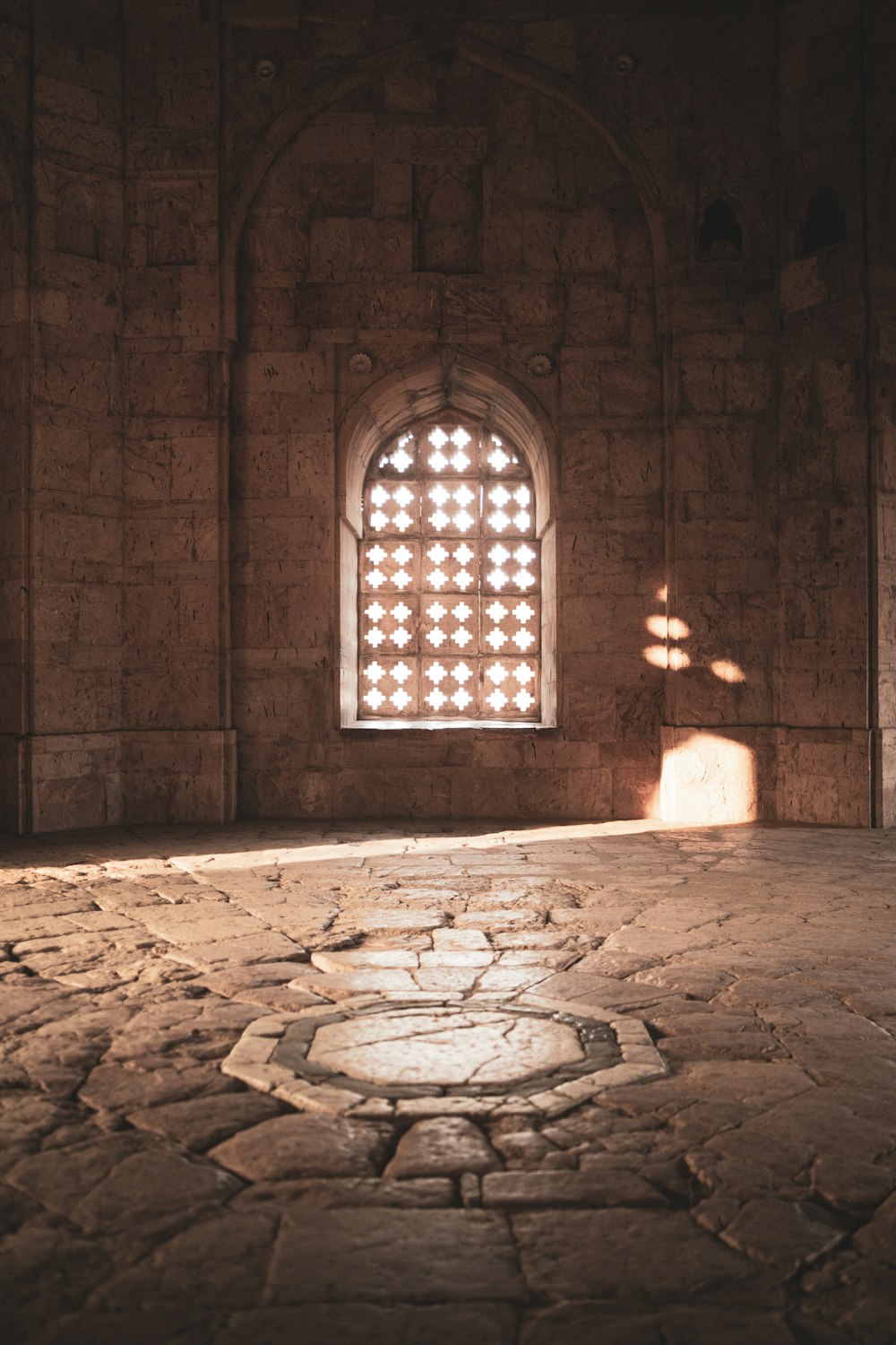 a room with a stone floor and a window