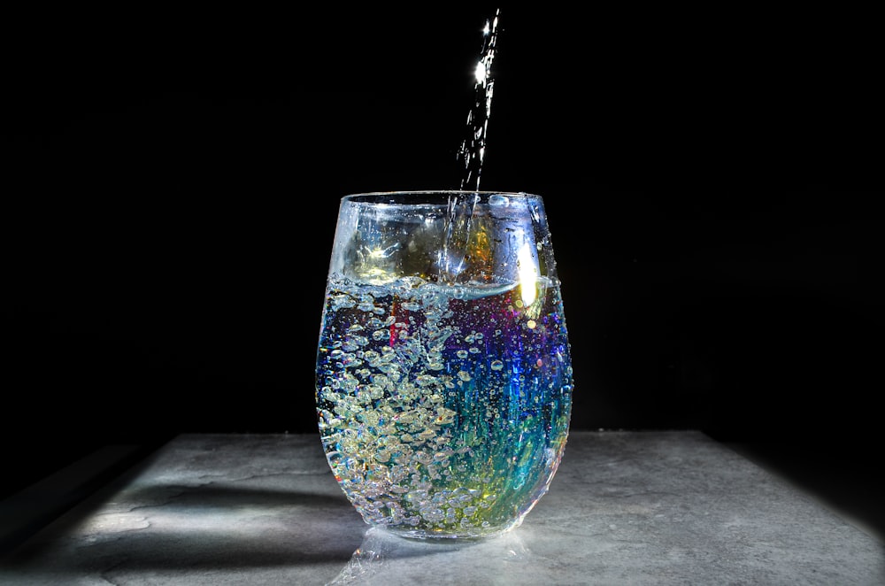 a glass filled with water sitting on top of a table