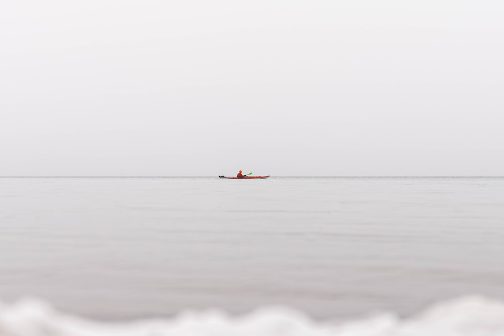 a small boat floating on top of a large body of water