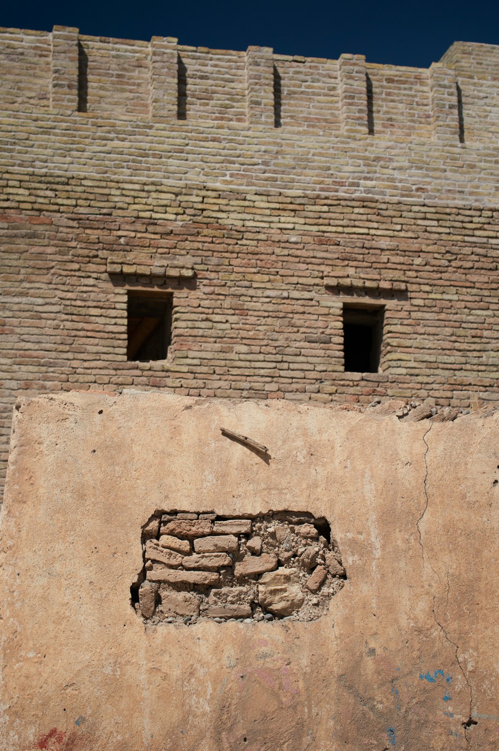 a stone building that has a clock on the side of a brick wall