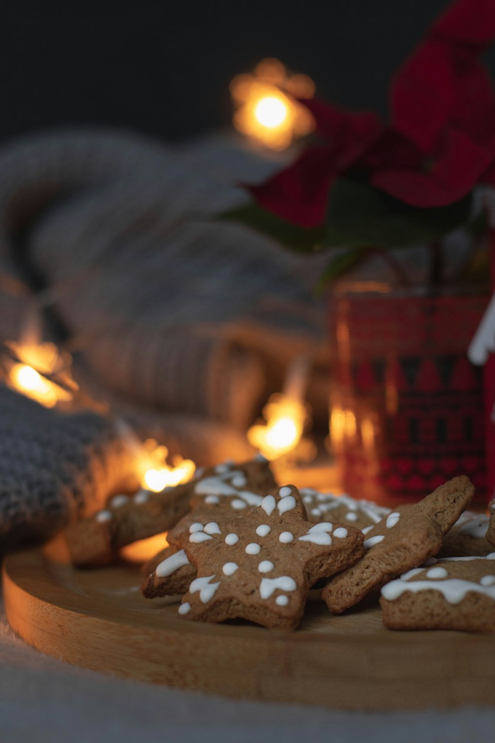 a wooden plate topped with cookies next to a potted plant