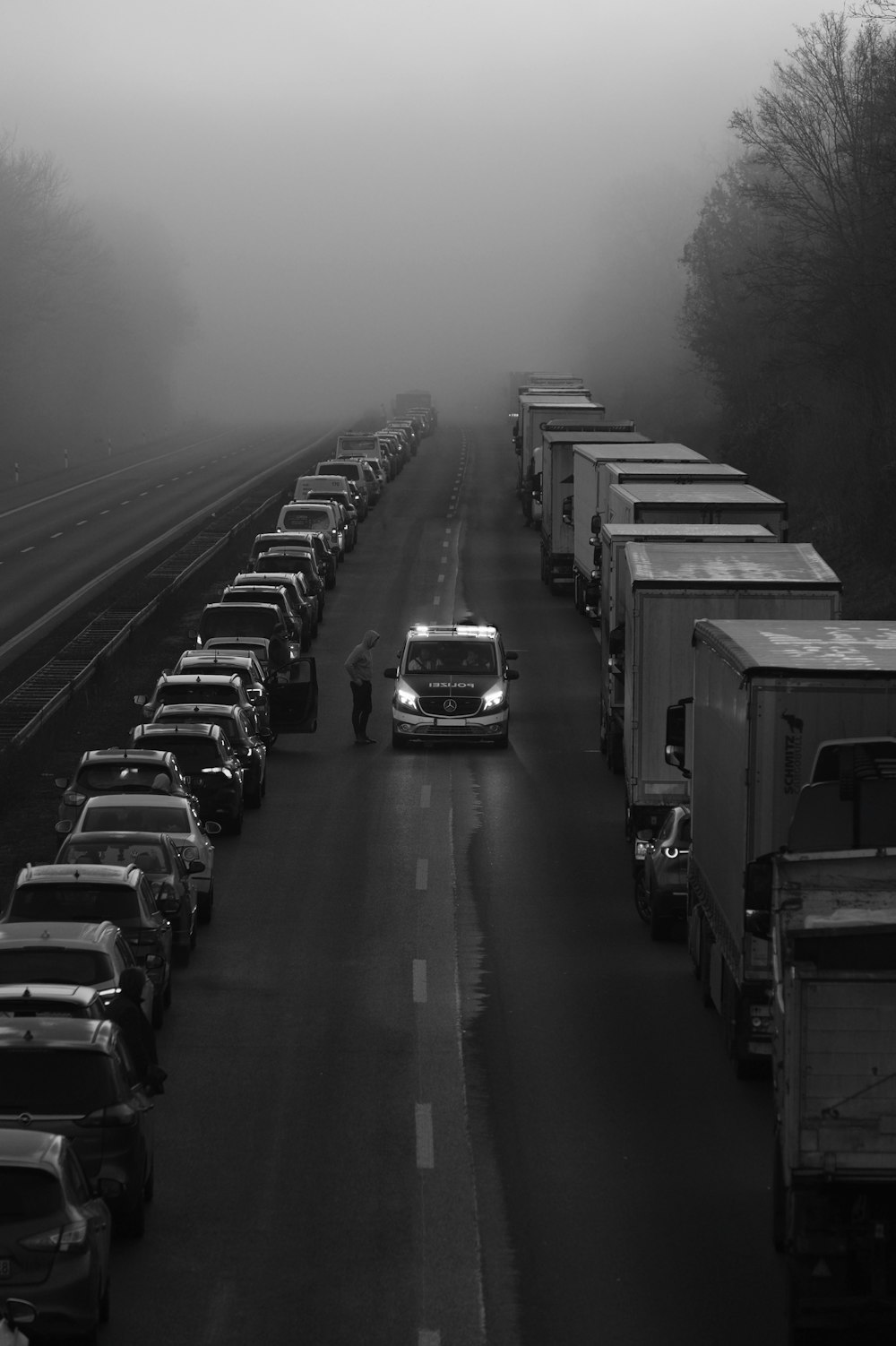 a black and white photo of a long line of trucks