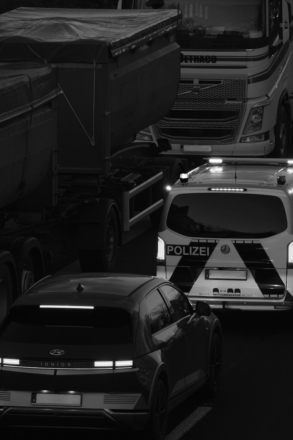 a black and white photo of cars and trucks