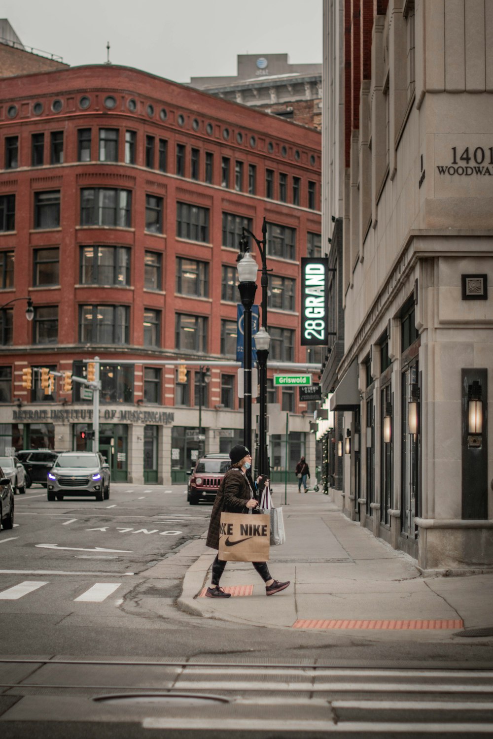 a woman walking across a street holding a sign