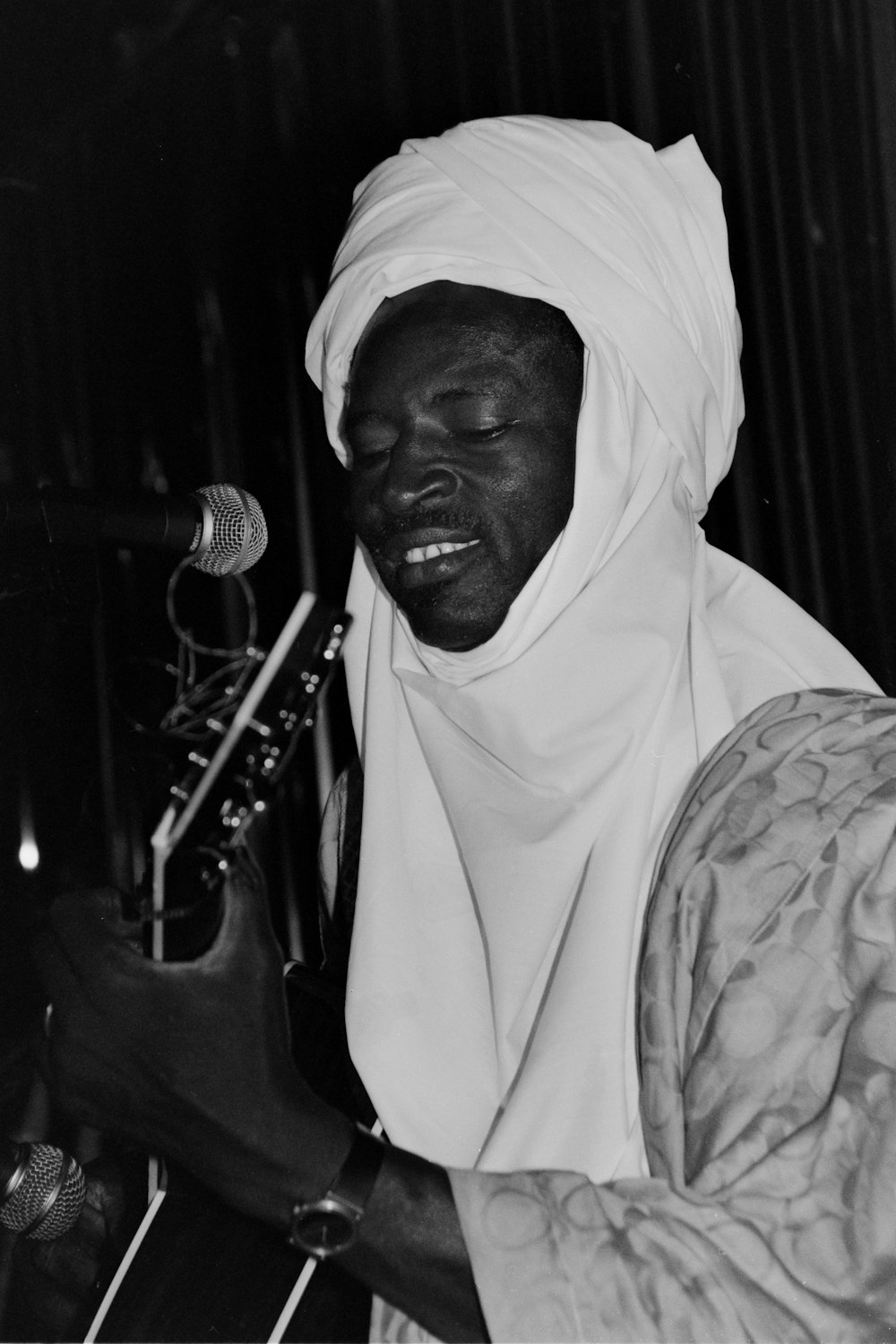 a black and white photo of a man playing a guitar