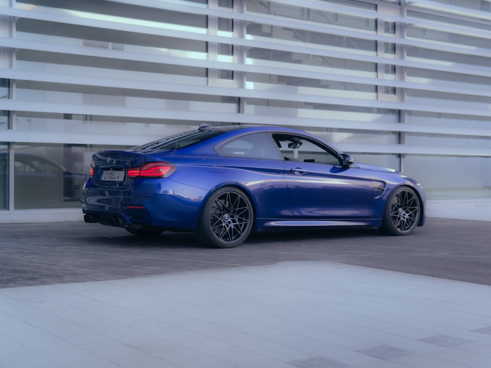 a blue car parked in front of a building