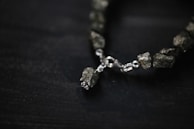 A close-up of a handmade bracelet featuring various quartz stones.