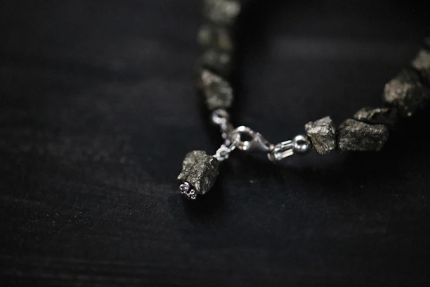 Close-up of edgy metal accessories like studded bracelets and rings on a dark, grunge background.