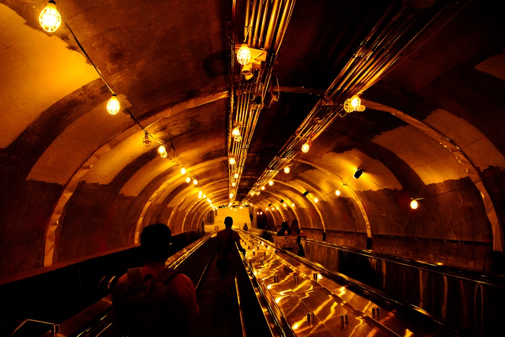 a person riding an escalator in a tunnel