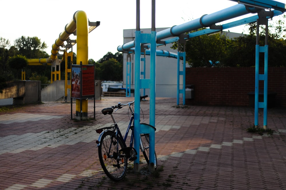 a bicycle is chained to a blue pole