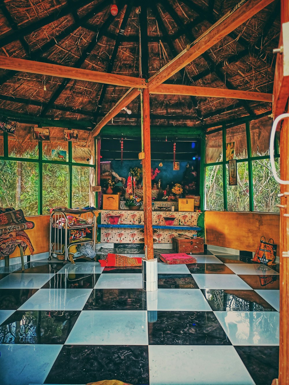 a room with a checkered floor and a thatched roof