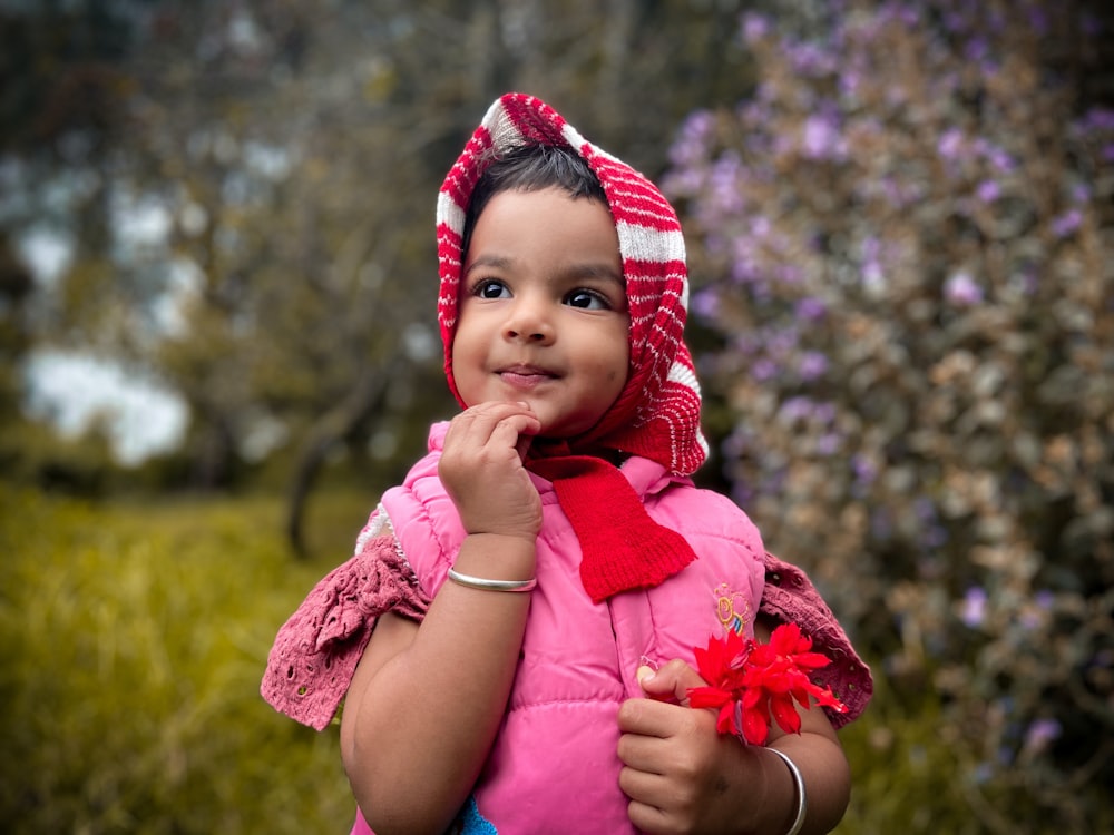 a little girl wearing a red and white hat and scarf