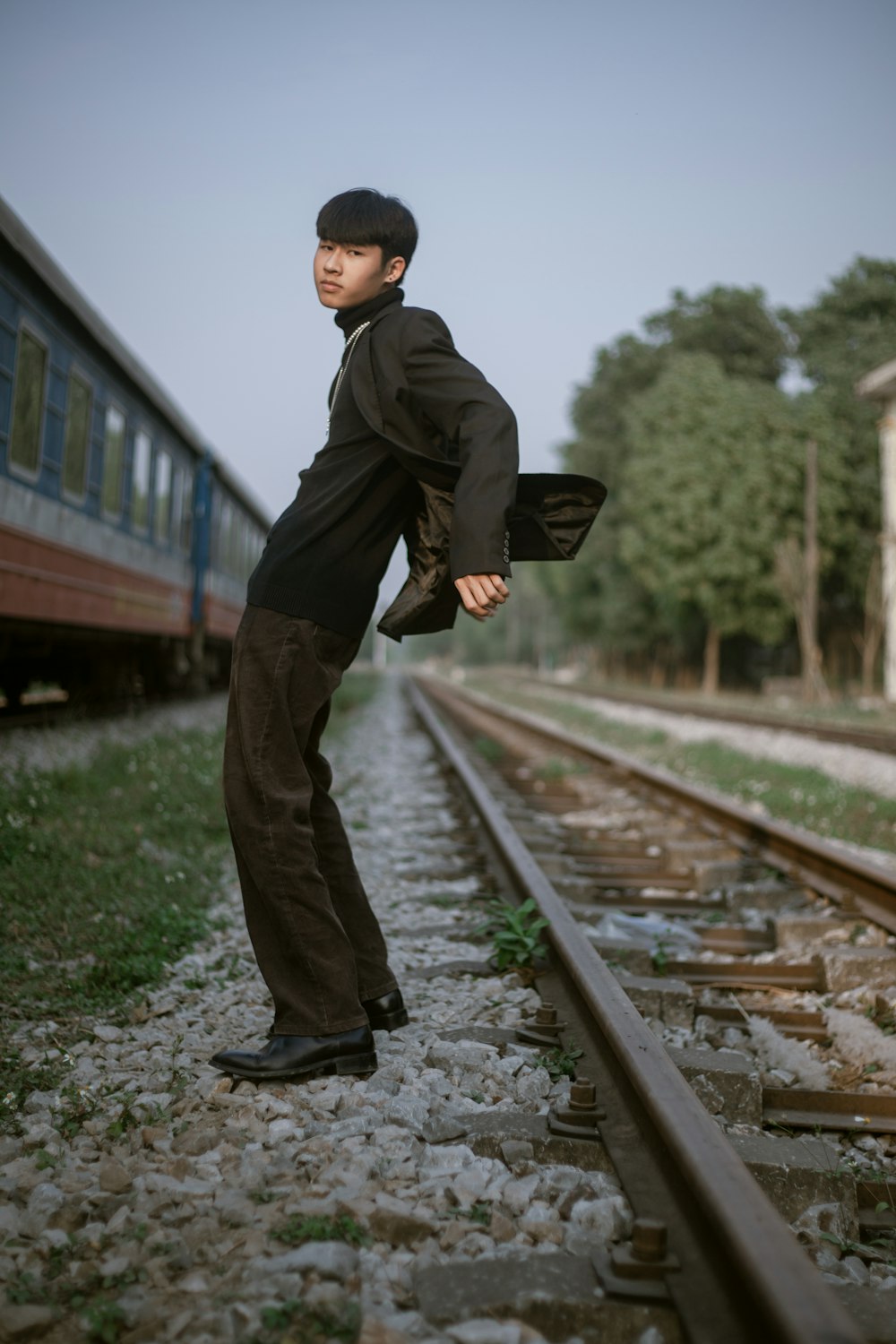 a man standing on a train track next to a train