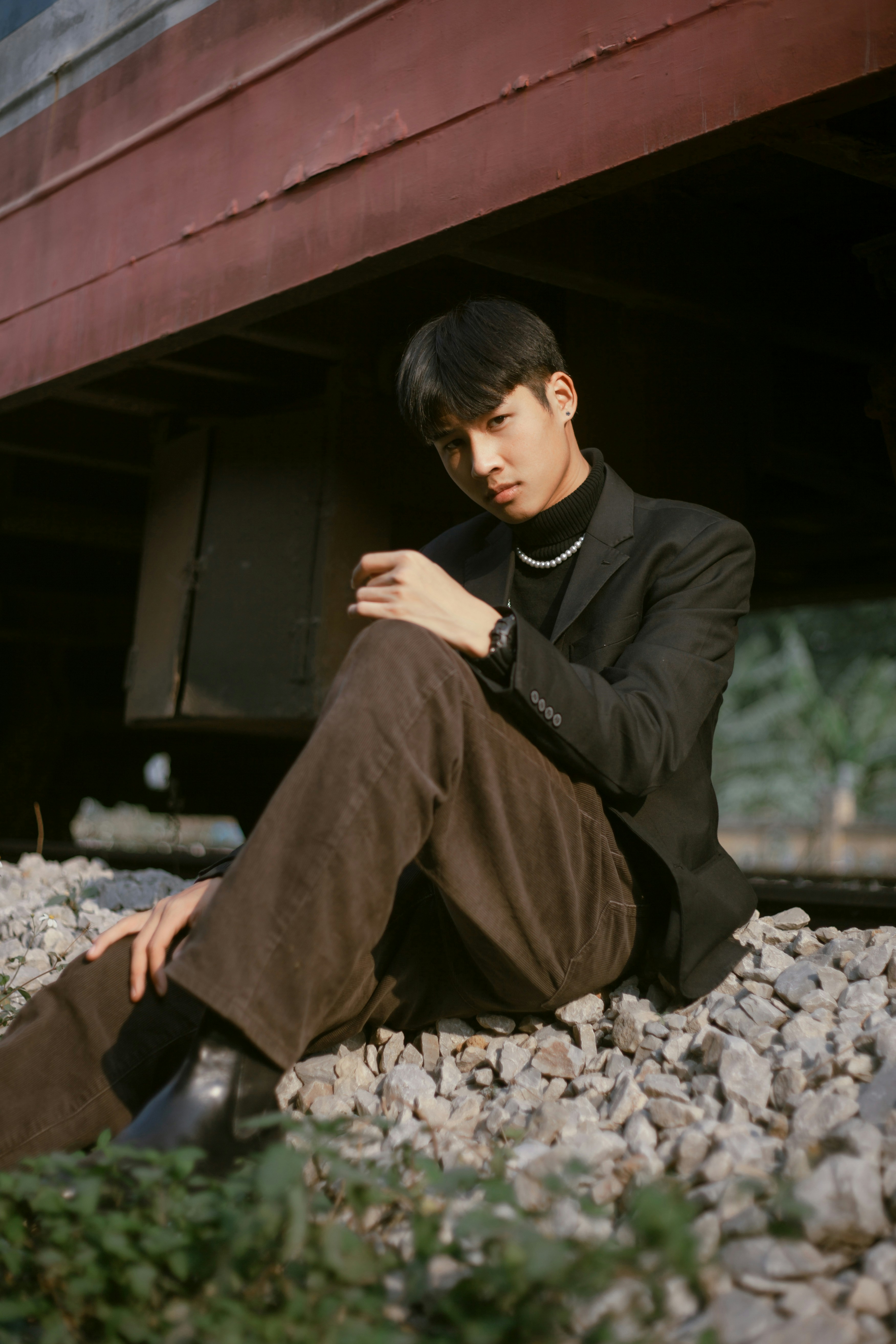 a man sitting on the ground next to a train