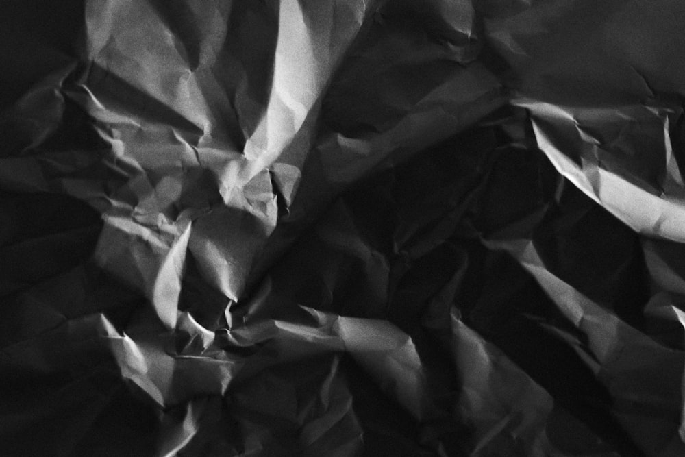 a black and white photo of crumpled paper