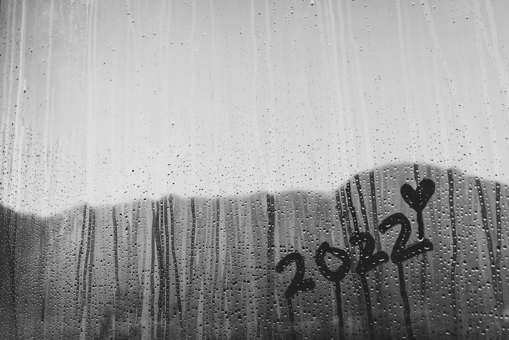 a black and white photo of rain drops on a window