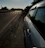 A roadside assistance vehicle parked beside a broken-down car on a sunny day.