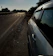 A roadside assistance vehicle parked beside a broken-down car on a sunny day.