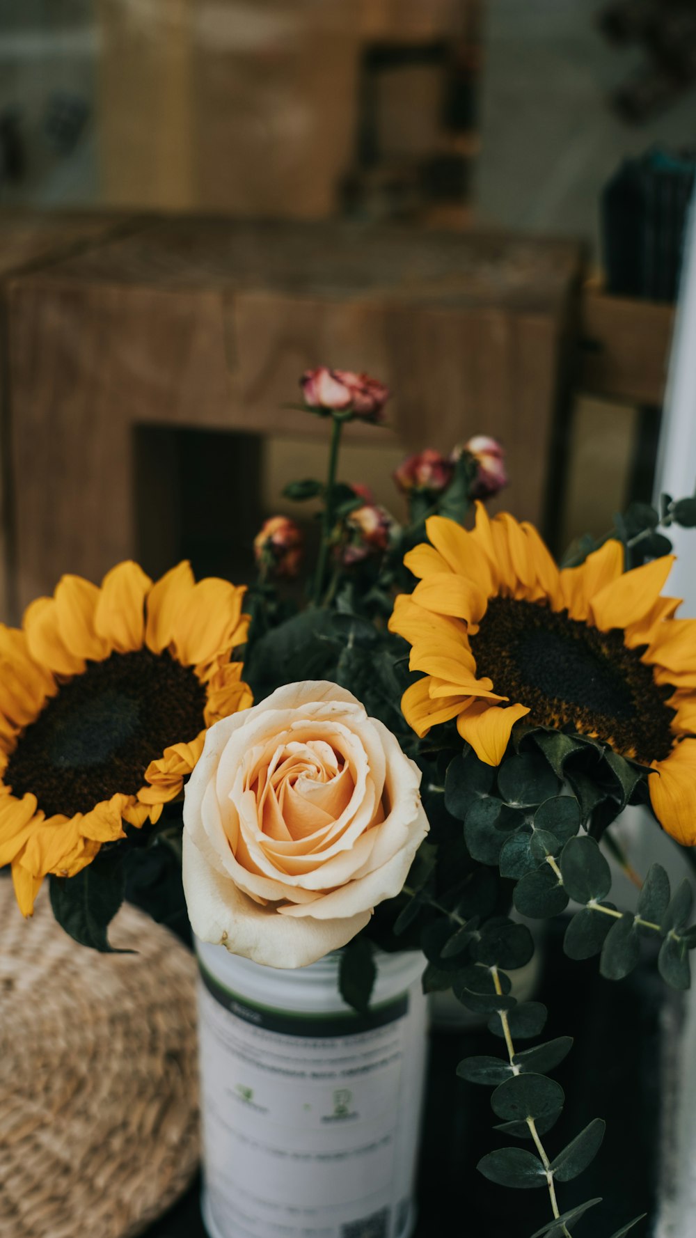 a bouquet of sunflowers and roses in a vase