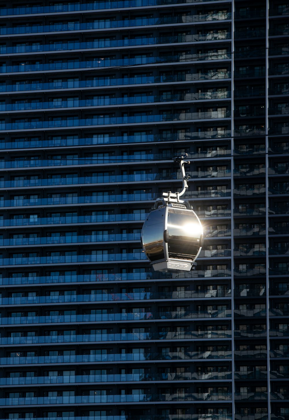 a cable car hanging from the side of a tall building