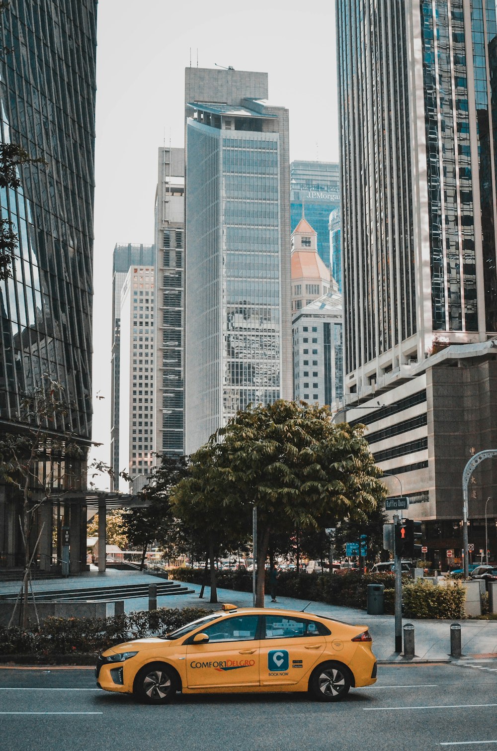 a yellow taxi cab driving down a street next to tall buildings