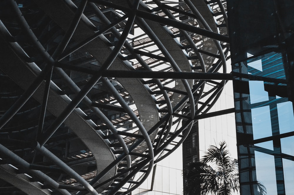 a tall building with a metal structure next to a palm tree