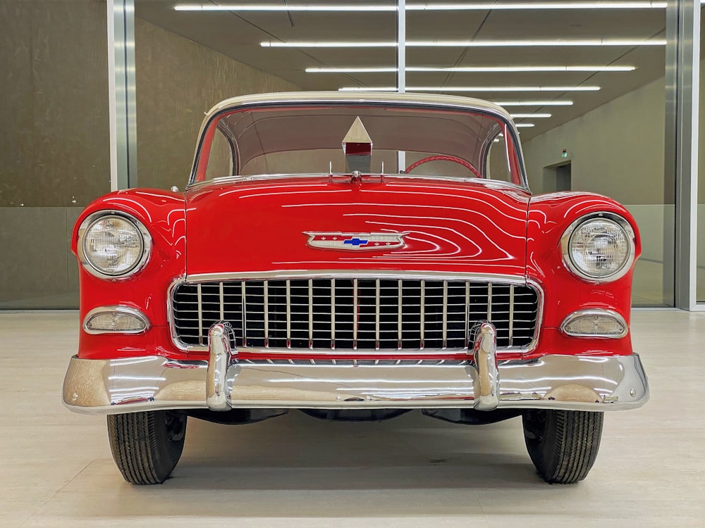 a red classic car parked in a garage