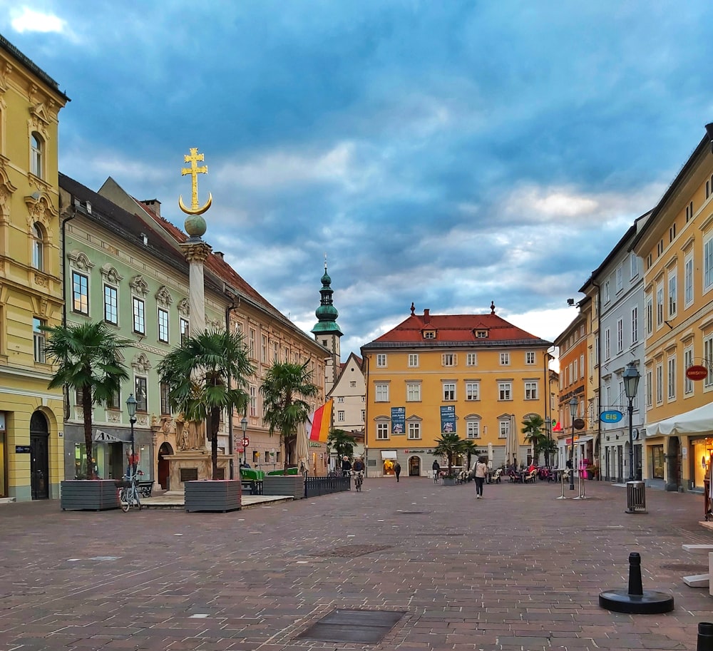 a city square with a clock tower in the background