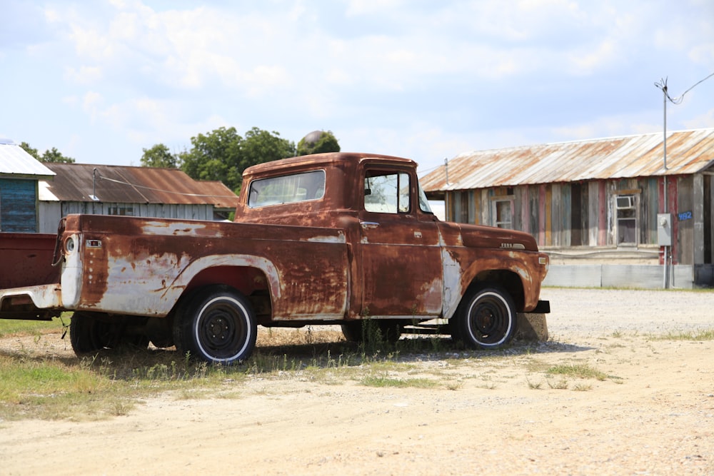 an old rusted truck is parked in a field