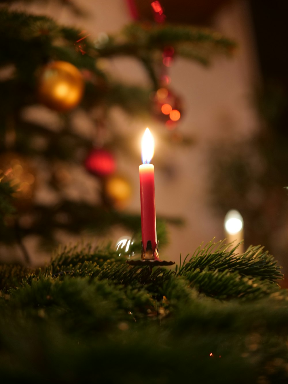 a lit candle sitting on top of a christmas tree