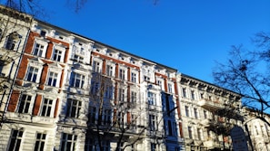 a tall building with lots of windows next to trees