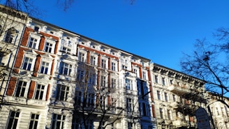 a tall building with lots of windows next to trees