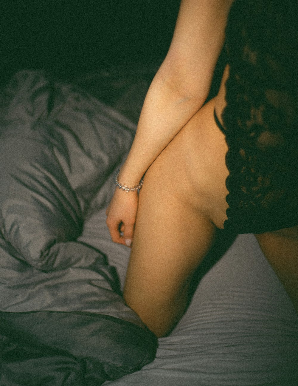 Eine nackte Frau sitzt auf einem Bett