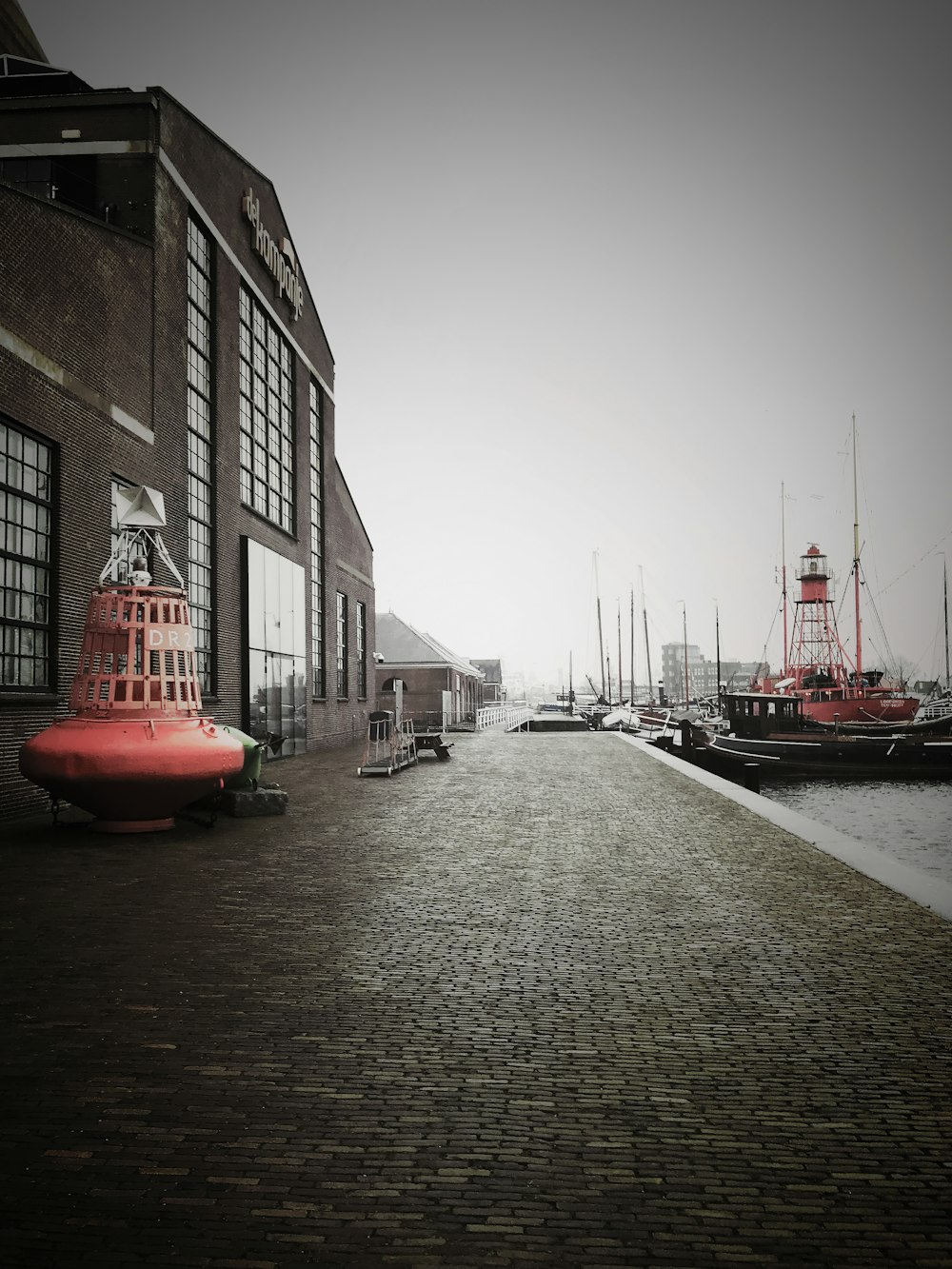 a red fire hydrant sitting on the side of a brick road