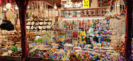 A vibrant display of colorful handcrafted toys and elegant gift items arranged on a wooden table.