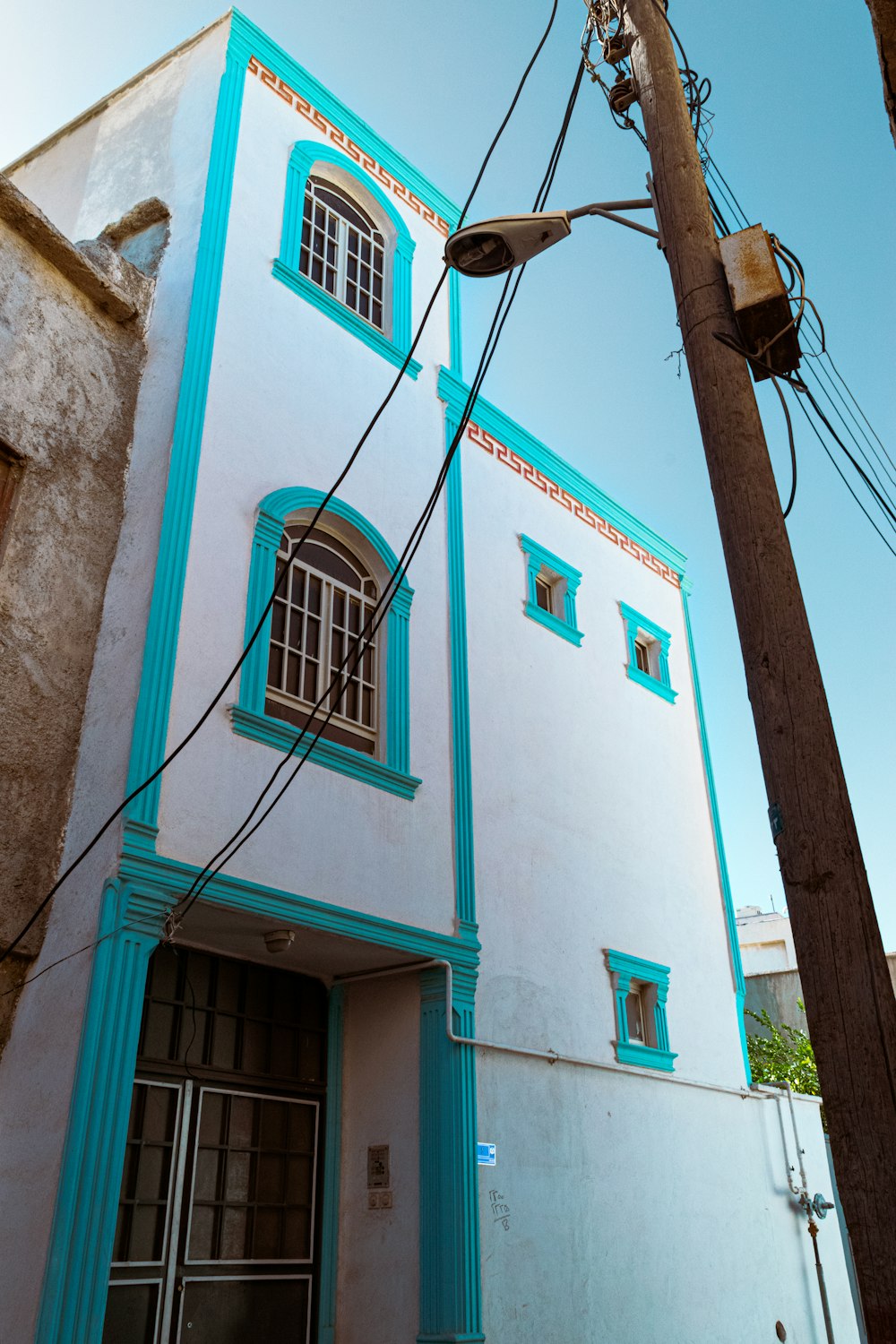 ein blau-weißes Gebäude mit einem Telefonmast davor