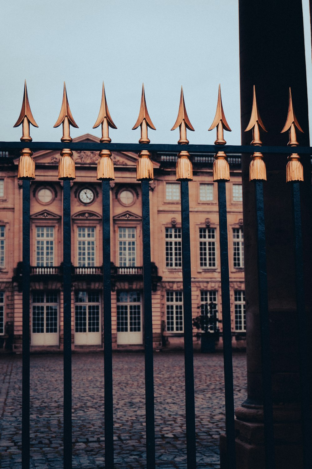 a building behind a fence with a clock on it