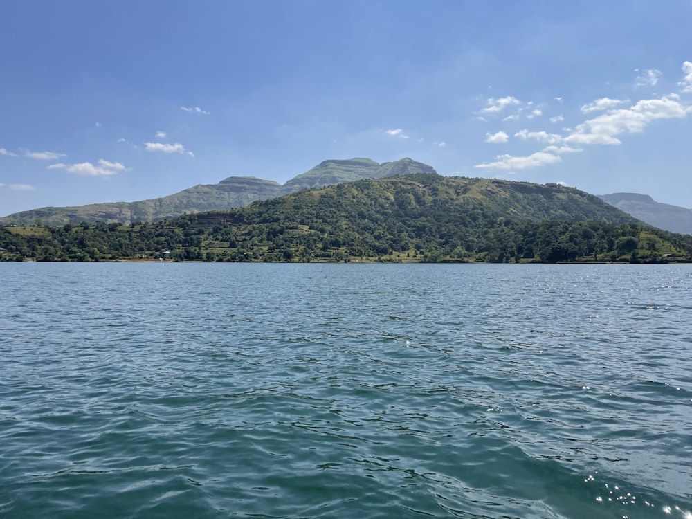 a large body of water with a mountain in the background