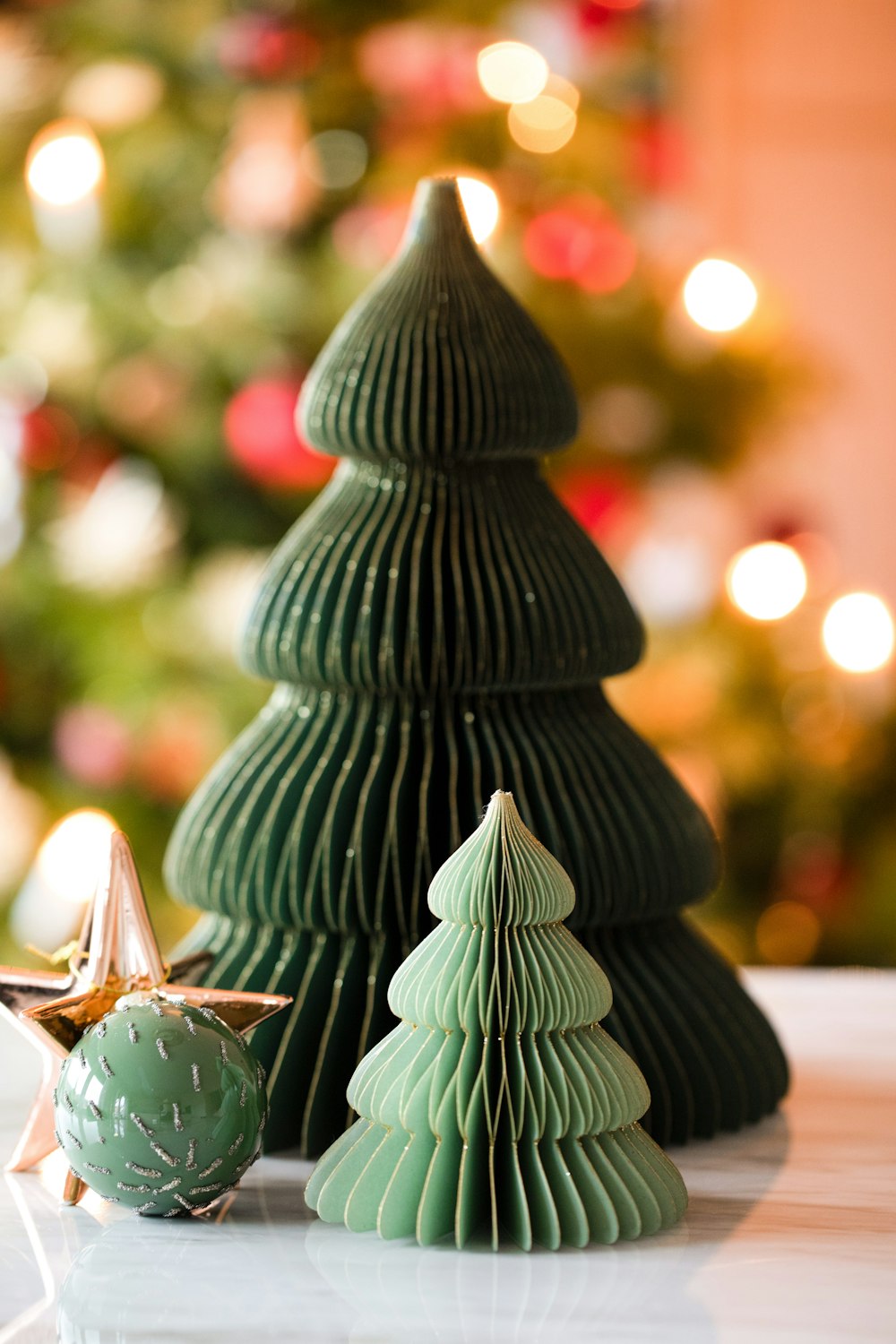 a small green christmas tree next to a small green ornament