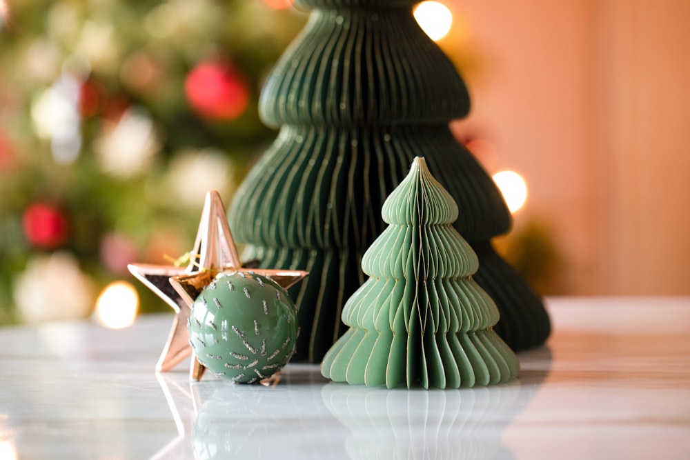 uma pequena árvore de Natal verde ao lado de um ornamento verde