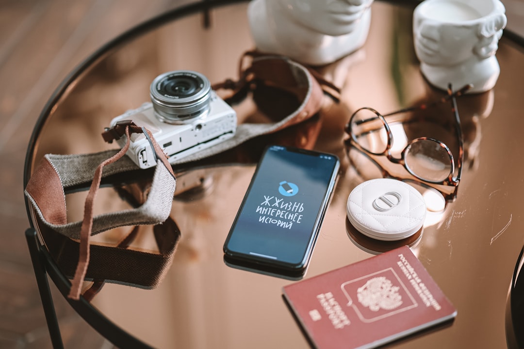 a table topped with a camera and a cell phone,