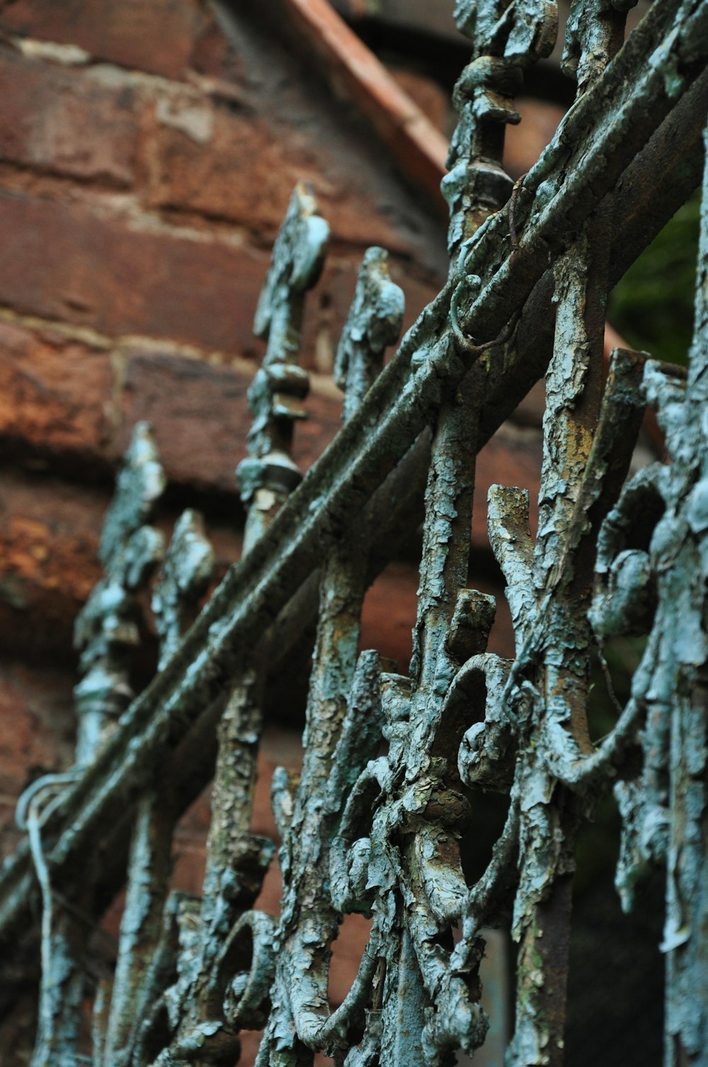 a close up of a metal fence near a brick building