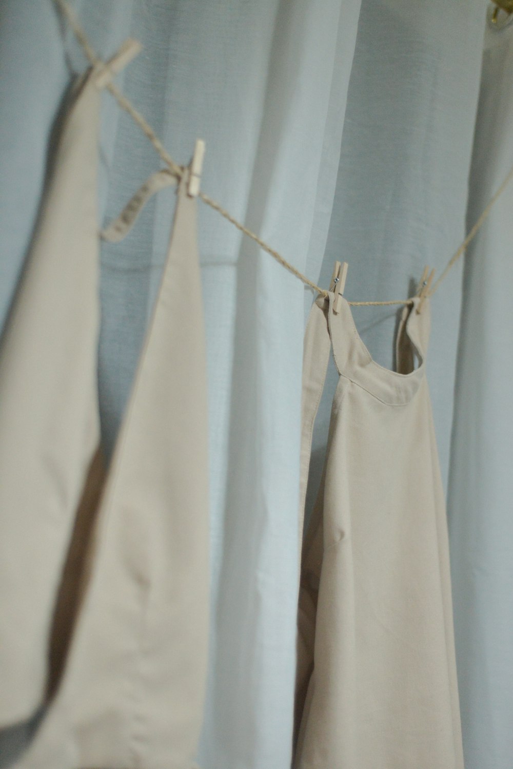 clothes hanging on a clothes line in front of a curtain