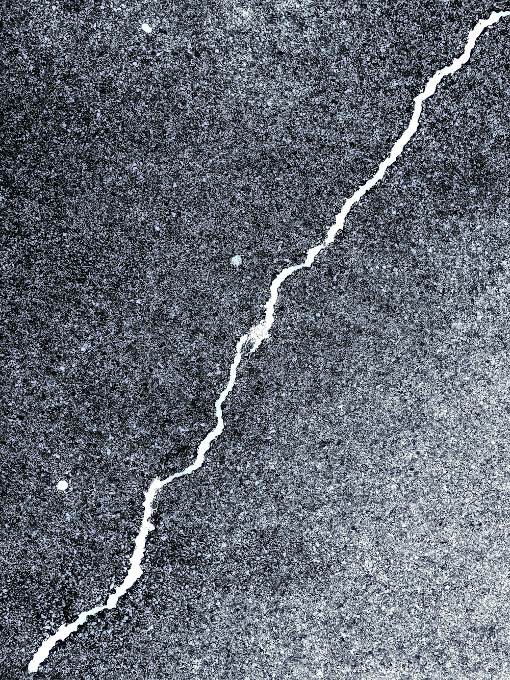 uma foto em preto e branco de uma rachadura no chão