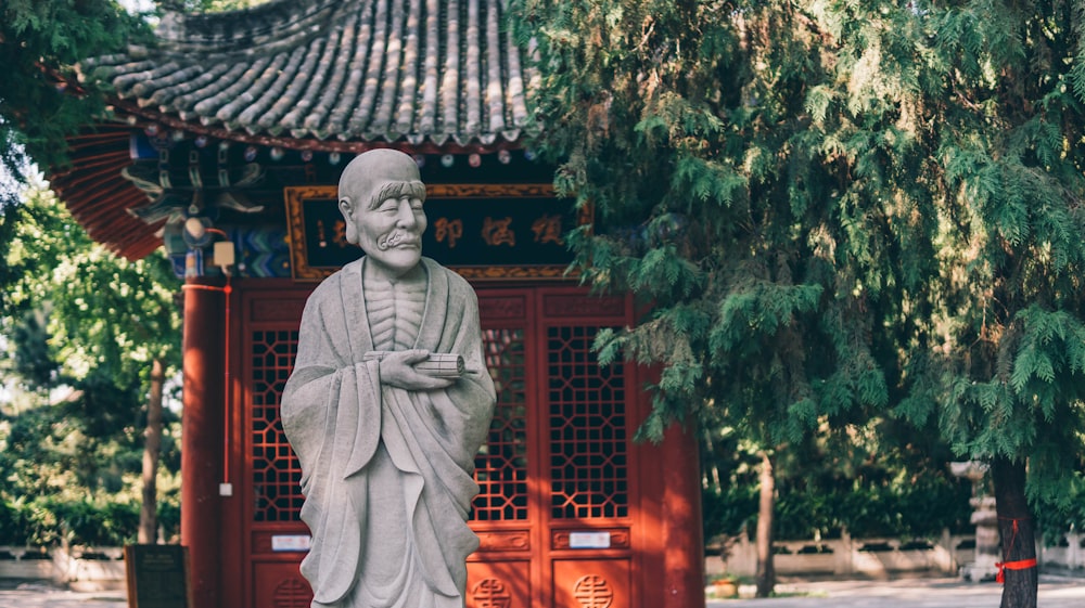 a statue of a man standing in front of a building