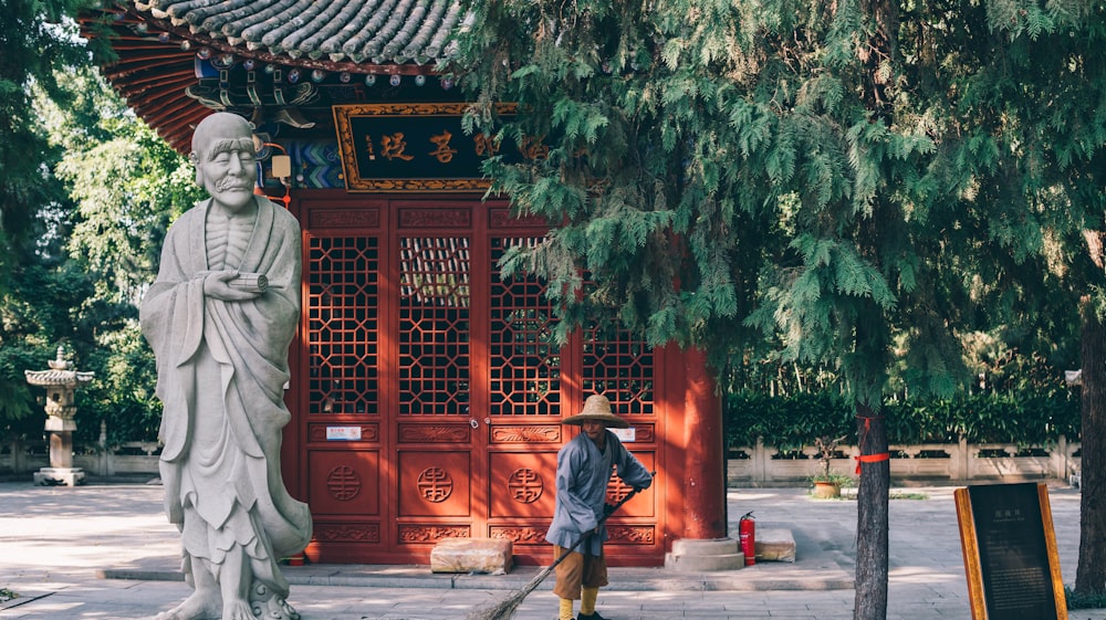 a man sweeping up a statue in front of a building